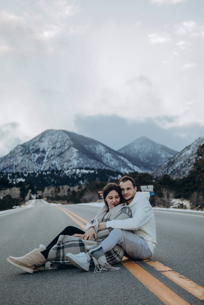 νεαρό ζευγάρι ερωτευμένο κάθεται στο δρόμο - Φωτογραφία, εικόνα