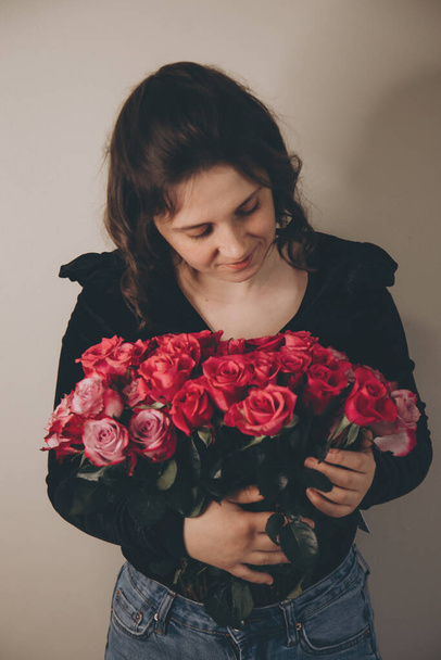 photo of a brunette girl with a bouquet of roses - 写真・画像