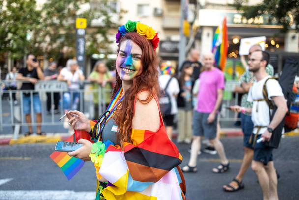 Haifa, Israel - June 24, 2023: People with protest signs in preparation to the annual LGBTQ pride parade. Girl waving a rainbow flag - Foto, Bild