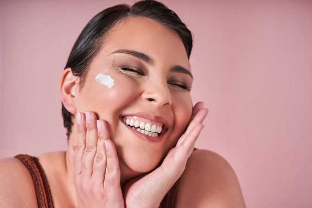 Cream, skincare and woman excited about product for body against on pink studio background. Face of a happy body positive model with smile for lotion or sunscreen for healthy glow - Fotoğraf, Görsel