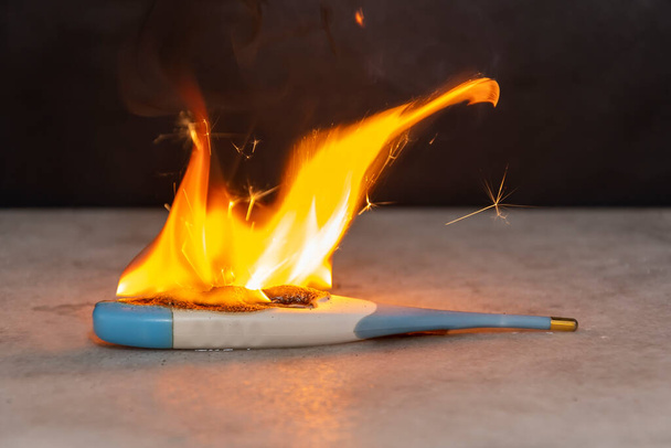 Electronic thermometer fire, flames, flames and sparks. Short circuit, bad battery contact. - Фото, зображення
