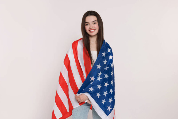 4th of July - Independence Day of USA. Happy girl with American flag on white background - Foto, afbeelding
