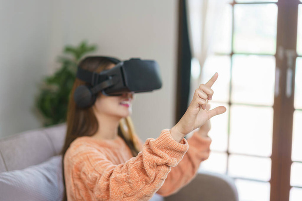 仮想現実のゴーグルで経験を楽しむために空中で触れる女性やビデオゲームを見て. - 写真・画像