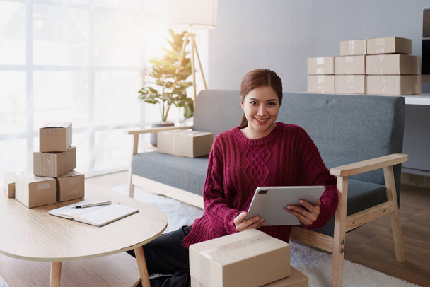 Laptop ve paket kutusu olan bir iş kadını. E-Ticarette KOBİ Başarı Sembolü - Fotoğraf, Görsel