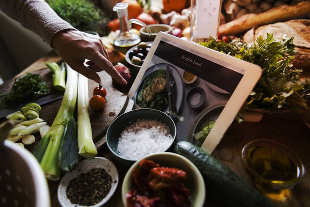 Una tableta digital en medio de un banco de cocina ocupado
 - Foto, Imagen