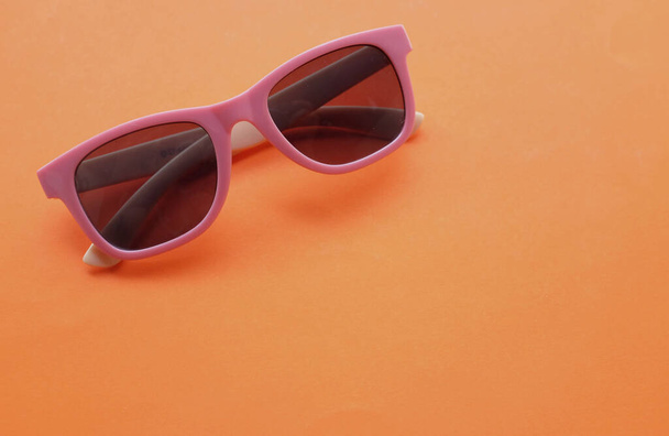lunettes de soleil rondes dans un cadre en plastique rose isolé sur un fond blanc. Style de cadre audacieux mode rétro - Photo, image
