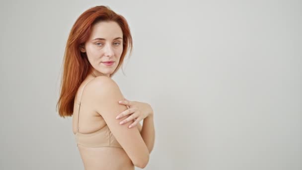 jonge roodharige vrouw dragen lingerie glimlachen over geïsoleerde witte achtergrond - Video