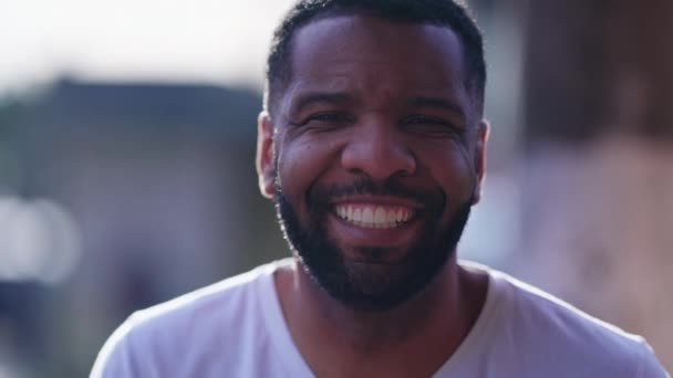 Een blije zwarte man lachend naar de camera, close-up gezicht van een vriendelijke Afro-Amerikaanse man in de 30. Braziliaanse echte mensen - Video