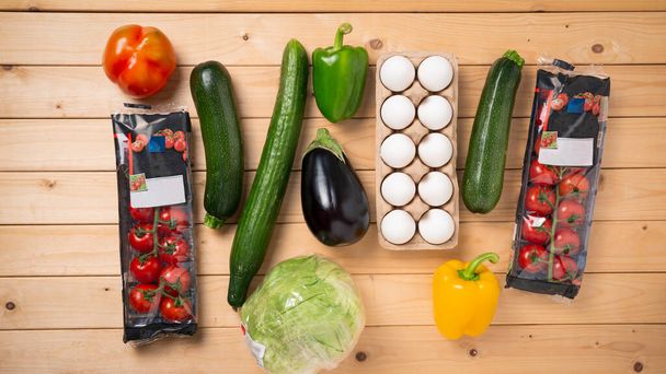 Набор вегетарианских овощей из супермаркета на деревянном столе, вид сверху - Фото, изображение