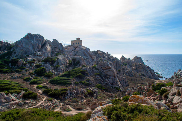 Rocky sea coast with a lighthouse in the Capo D'Orso area on the island of Sardinia, Italy - Fotó, kép