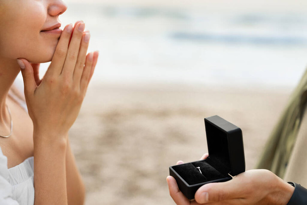 Залучення. Чоловік задає дівчині питання про шлюб, пропонуючи одружитися з ним на пляжі, крупним планом, обрізаним. Любов, концепція стосунків - Фото, зображення