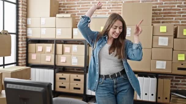 Νεαρή όμορφη ισπανόφωνη γυναίκα του ηλεκτρονικού εμπορίου εργαζόμενος χαμογελά αυτοπεποίθηση χορό στο γραφείο - Πλάνα, βίντεο