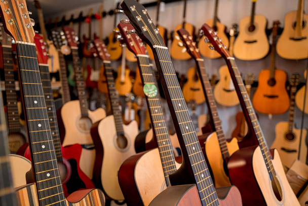 Many rows of classical guitars in the music shop. - Zdjęcie, obraz