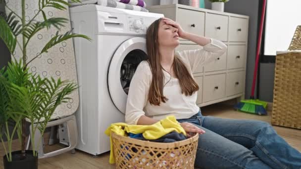 Çamaşırhanede yorgun bir şekilde oturan güzel İspanyol kadın çamaşırları yıkıyor. - Video, Çekim
