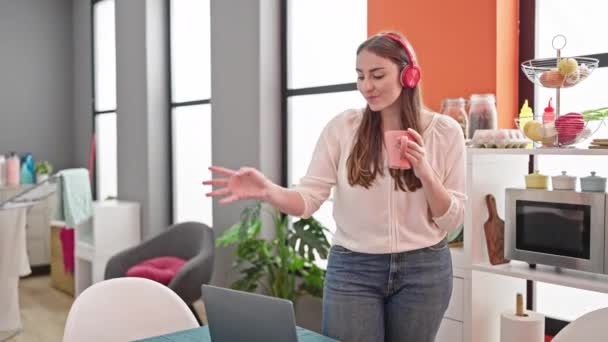 Giovane bella donna ispanica ascoltare musica e ballare bere caffè in sala da pranzo - Filmati, video