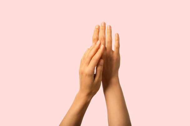 Detailní záběr rukou nanášení krému perfektní pleť a úhledné neutrální nehty. - Fotografie, Obrázek