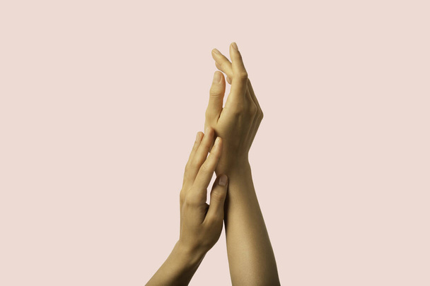 Čerstvé a čisté ruce kůže s přesnou neutrální manikúrou na růžovém pozadí. - Fotografie, Obrázek