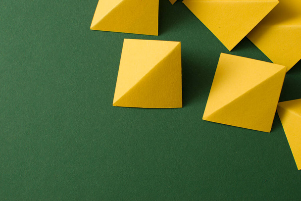 Yellow triangle shapes on green background with copy, empty space - Valokuva, kuva
