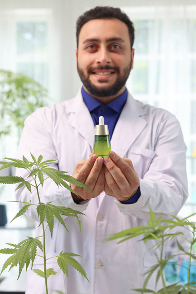 Vědec drží marihuanový olej v laboratoři, biochemik dělá experiment s konopným listem, lékárník extrakt aromatický konopný olej v laboratoři, zdravotnický pracovník pracuje pro alternativní bylinné medicíny. - Fotografie, Obrázek
