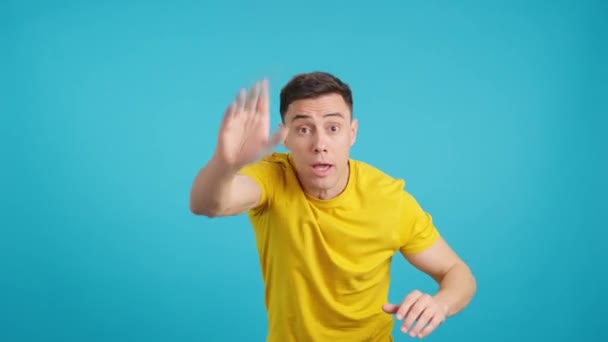 Videó a stúdióban, kék háttérrel egy férfi gesztus, hogy kövessék a bulizás - Felvétel, videó