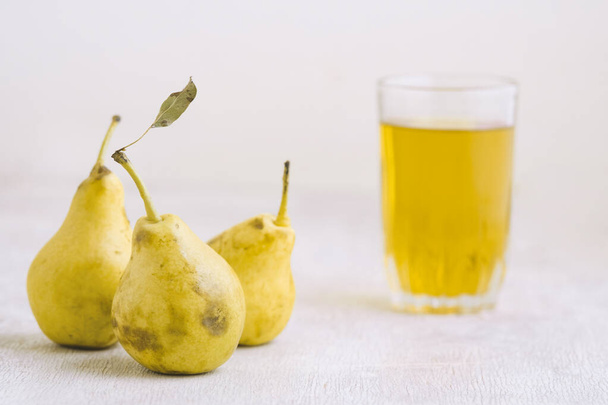Juice of pears  in a glass on a white wooden background - Foto, Bild