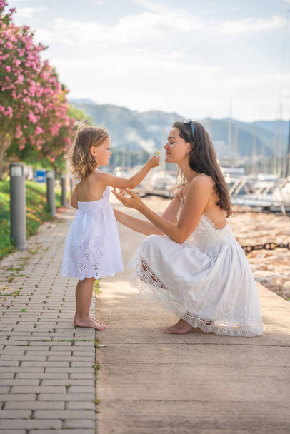 Šťastná matka a dcera dítě baví na luxusních jachtách na pozadí v přístavu. Rodinné cestování, životní styl, dovolená. Kvalitní fotografie - Fotografie, Obrázek
