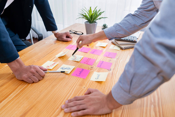 Üzleti csapat összegyűlnek az asztalon, ötletelés és írás kreatív ötlet színes post-it jegyzetek. Tervezés és ötletbörze stratégia az üzleti célok eléréséhez. buzgó - Fotó, kép
