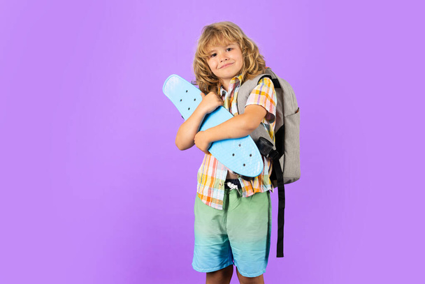 Bambino con skateboard in studio. Il ragazzo si diverte con il penny board. Penny board, skateboard per bambini. Bambino di moda in camicia - Foto, immagini