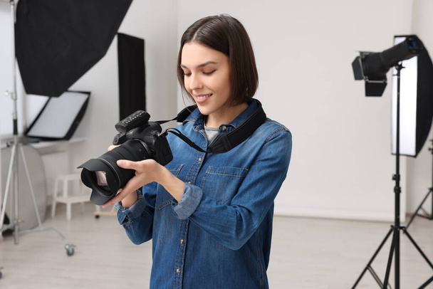 Professional photographer with camera in modern photo studio - Photo, Image