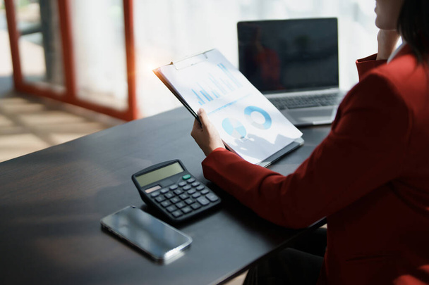 Młoda azjatycka kobieta pracuje z papierami finansowymi w domu liczyć na kalkulator przed płaceniem wpływów podatkowych online, planowanie budżetu chętnie znaleźć szansę na oszczędność pieniędzy, koncepcje audytu. - Zdjęcie, obraz