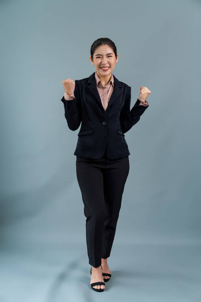 Уверенная молодая азиатская бизнесвумен в формальном костюме делает жест рукой, чтобы показать продвижение или рекламу с удивленным выражением лица и жестом на изолированном фоне. Энтузиазм - Фото, изображение