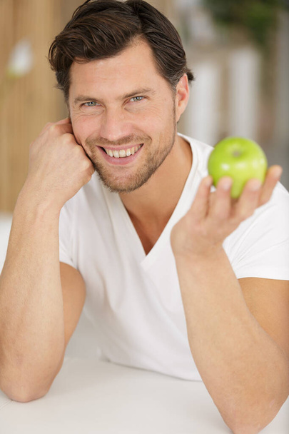 handsome man holding an apple - Fotó, kép