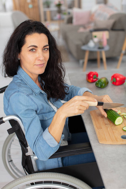 mature woman in wheelchair cooking - Photo, Image