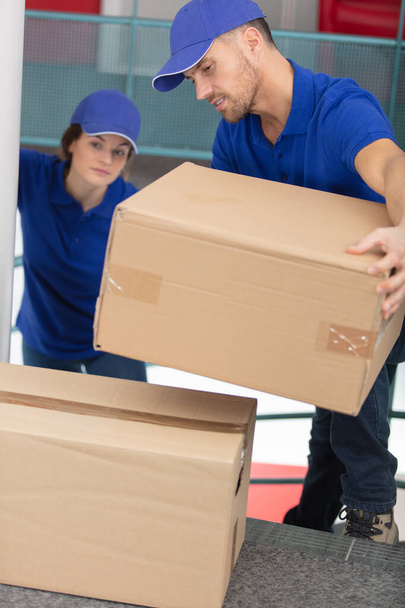 male and female movers carrying boxes - Foto, Bild
