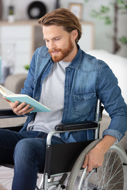 mozgássérült férfi tolószékben egy könyvvel - Fotó, kép