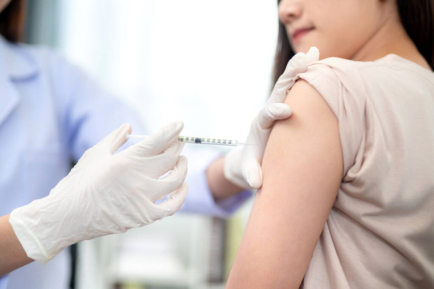Lekarz wykonujący szczepienie w ramię pacjenta, wstrzyknięcie szczepionki przeciw grypie na ramię.  - Zdjęcie, obraz
