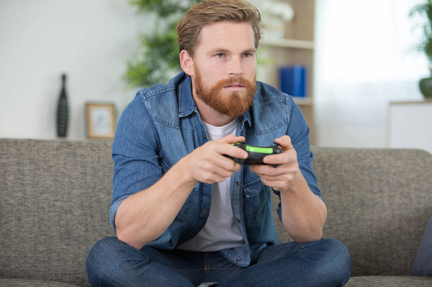 young man with joystick controller for console playing - Foto, Bild