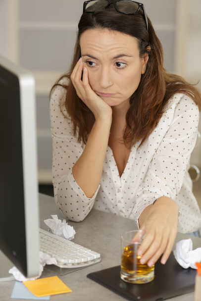 depressed woman drinking alcohol while using computer - Foto, Imagem