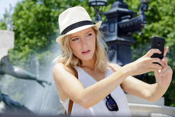 woman taking selfie in front of fountain - Foto, immagini