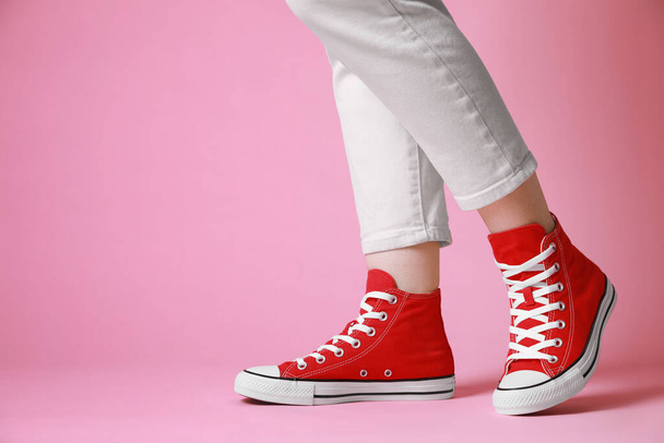 Woman wearing pair of new stylish sneakers on pink background, closeup. Space for text - Fotografie, Obrázek