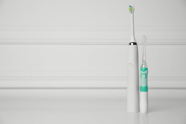 Electric toothbrushes on white background, space for text - Foto, imagen