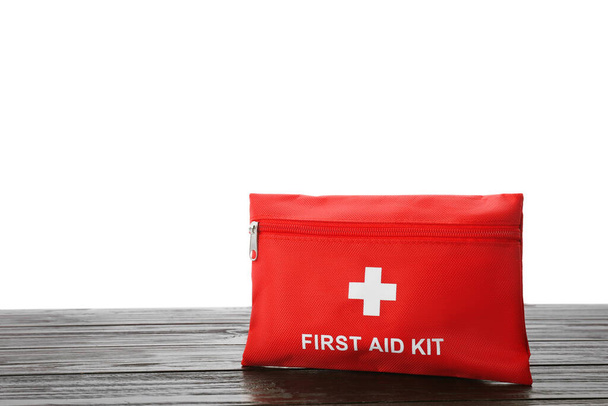 First aid kit on wooden table against white background - Φωτογραφία, εικόνα