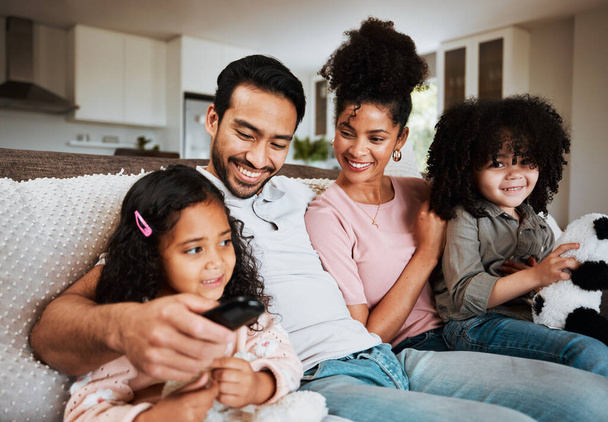 Mom, dad and happy kids on couch, watching tv and family bonding together in living room. Smile, happiness and parents relax with children on sofa, streaming television show subscription or movies - Fotó, kép