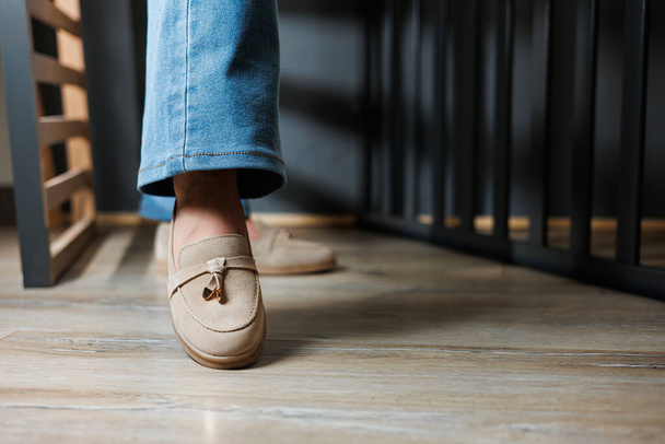 Primer plano de las piernas femeninas en jeans y mocasines beige de cuero genuino. - Foto, imagen