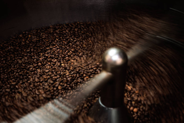 Kaffeeröster-Maschine beim Kaffeerösten-Mischprozess. Geröstete Spinnkühler professionelle Maschinen und frische braune Kaffeebohnen, Low-Speed-Auslösebewegung und Bewegung verwischen Kaffeekorn, Konzept - Foto, Bild