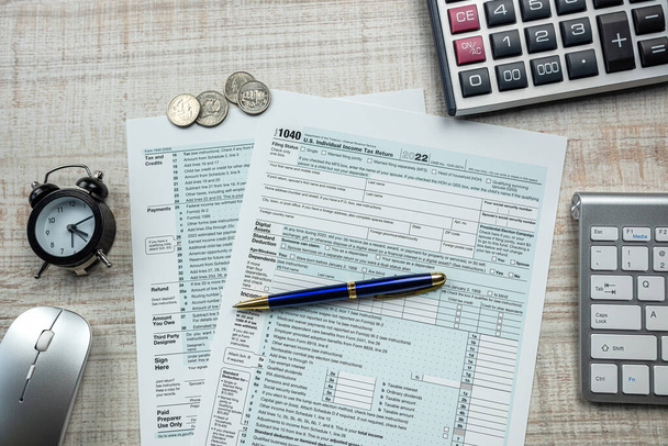 1040 lápiz formulario de impuestos con calculadora y despertador. Pago anual de impuestos  - Foto, imagen