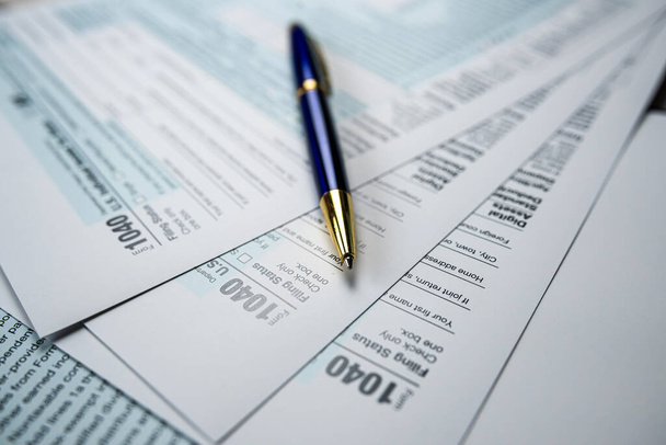 Concepto de rellenar el formulario de declaración de impuestos 1040 con pluma. Tiempo para impuestos - Foto, Imagen
