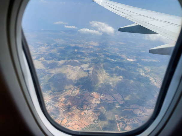 Se eleva por encima de las vistas panorámicas de Mallorcas en un jet privado, capturando la belleza de la naturaleza a través de un ala de avión transparente. Experimenta la alegría de viajar y la libertad en el paraíso de España. - Foto, imagen