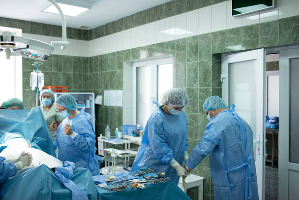 La squadra medica che esegue i tagli cesarei. Il medico tiene il bambino che partorisce sua madre per vedere - Foto, immagini