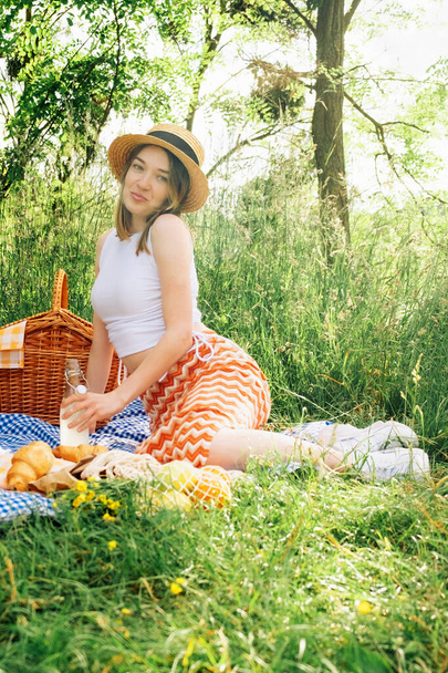 Outdoorsy young woman on blue blanket, having picnic - Zdjęcie, obraz